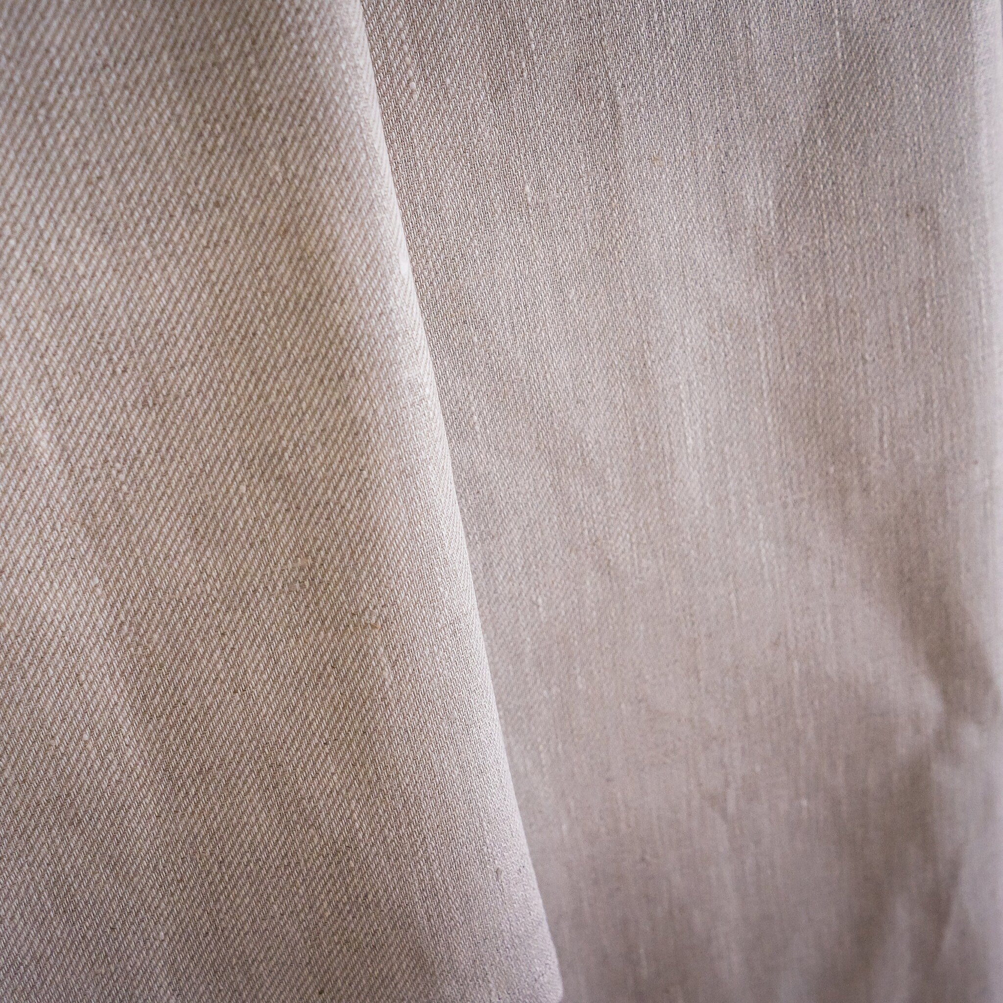 Beige fabric with diagonal weave pattern and textured material detail