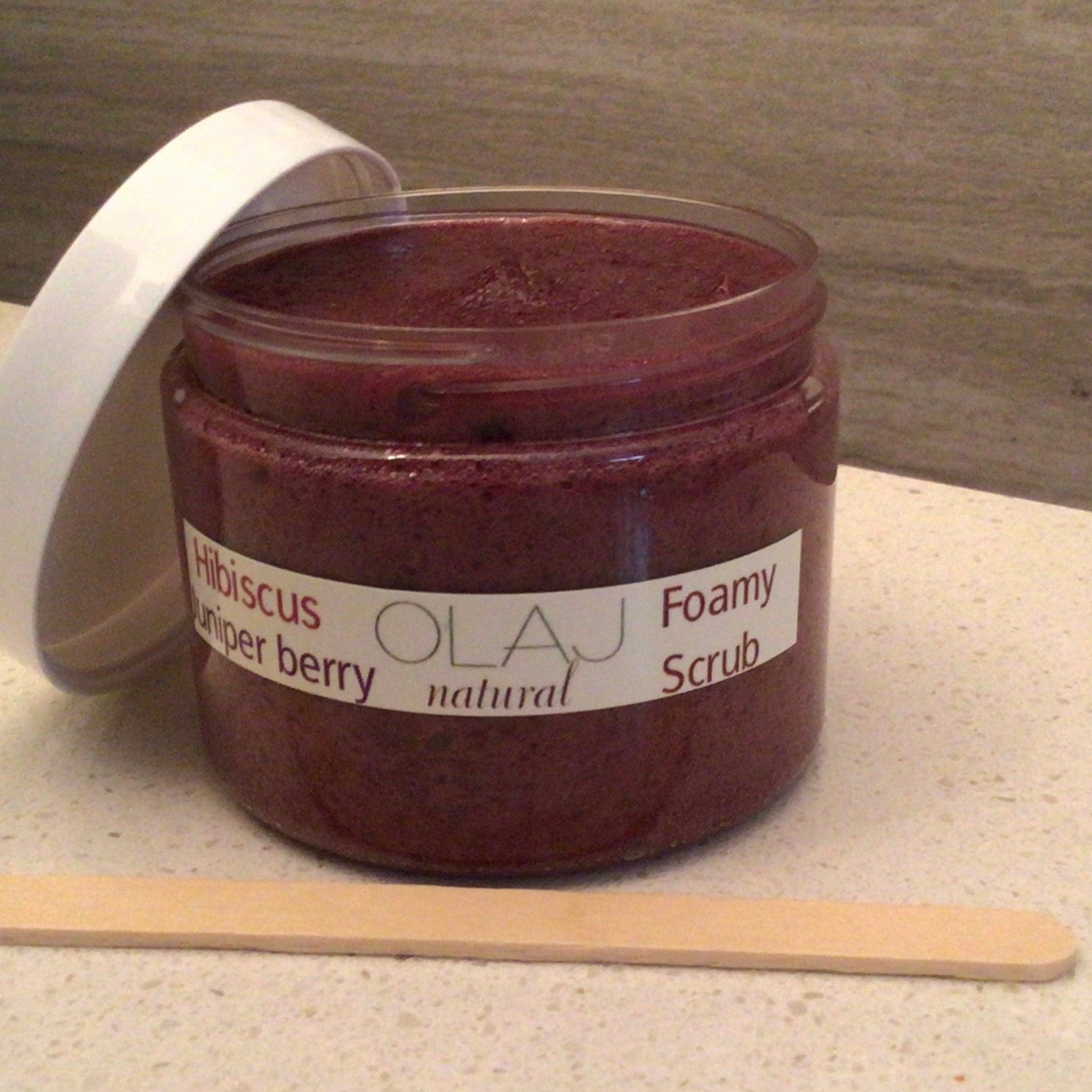 Foamy scrub jar with white lid, red scrub, and OLaj Natural label