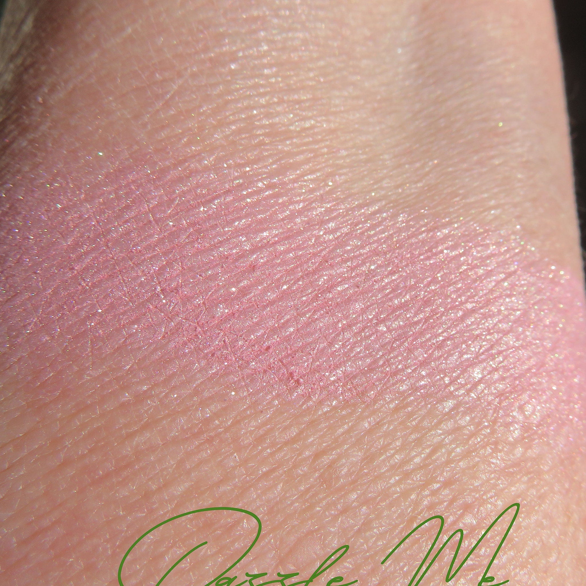 Side view of loose pink-gold shimmer eyeshadow pot showing mineral pigment texture and vegan label details
