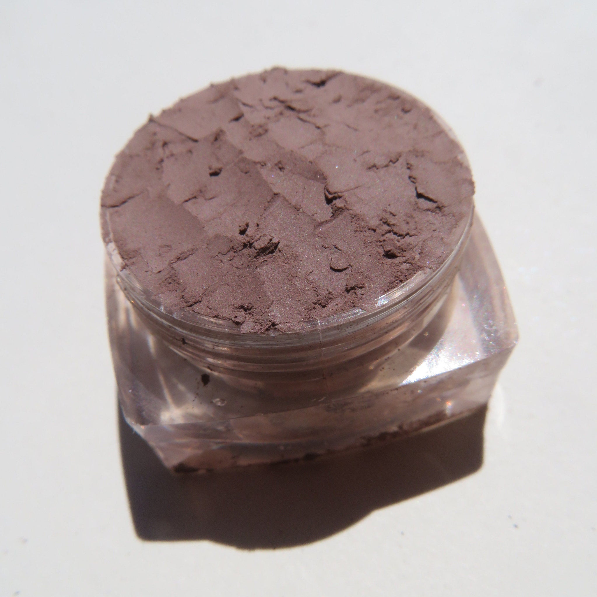 Open compact showing matte taupe brown mineral eye shadow with vegan loose pigment inside