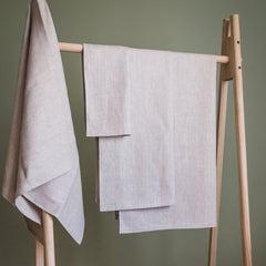 Linen towels, light beige, textured fabric, hanging on wooden rack