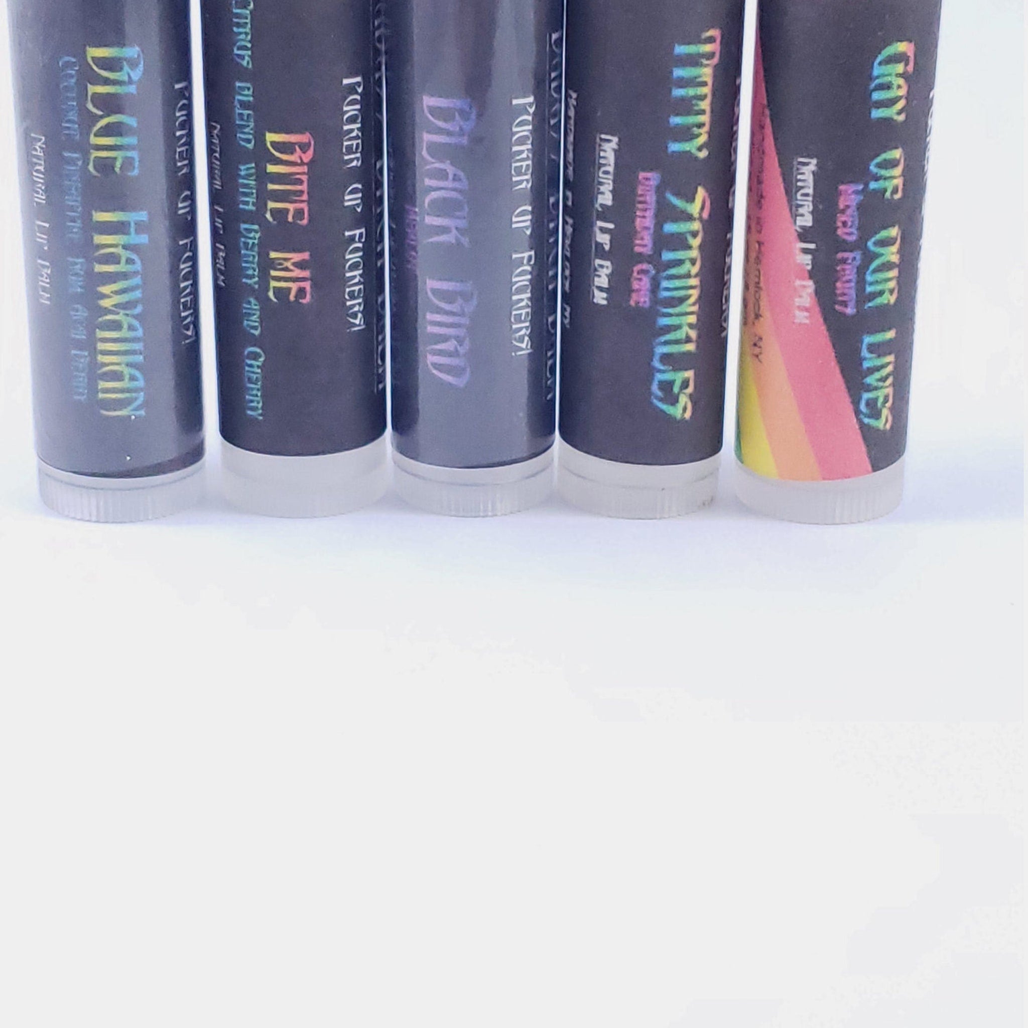 Lip balm tubes with black, iridescent text, and white base, various flavors visible