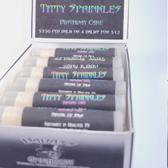 Lip balm tubes with black labels, clear tubes, and "Titty Sprinkles" text in rainbow colors.