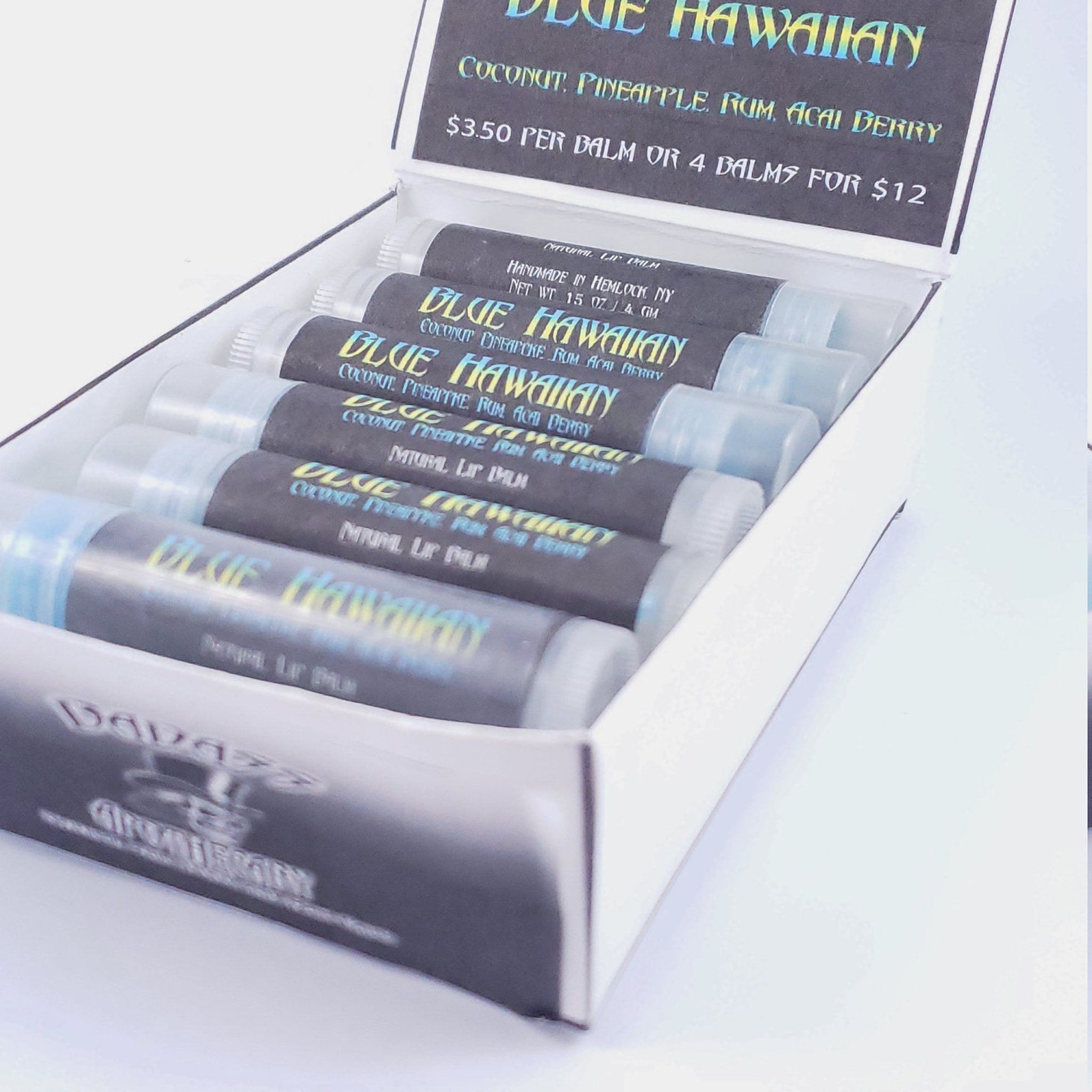 Lip balm tubes with blue and black labels in a white box, "BLUE HAWAIIAN" text visible