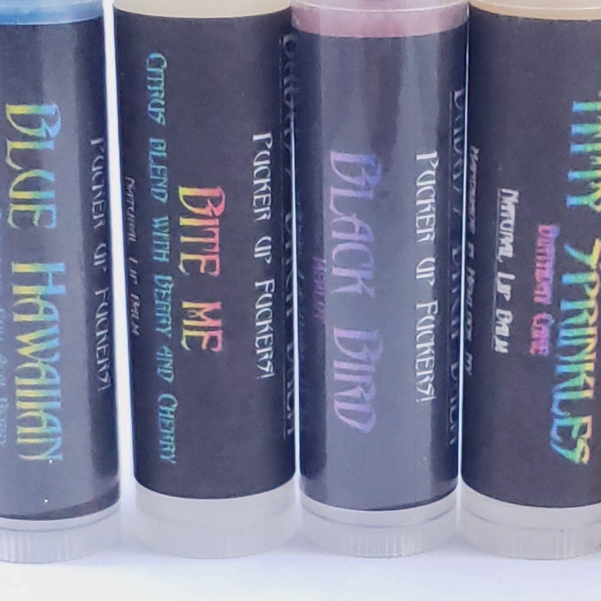 Lip balm tubes with black and white labels, holographic text, and clear base