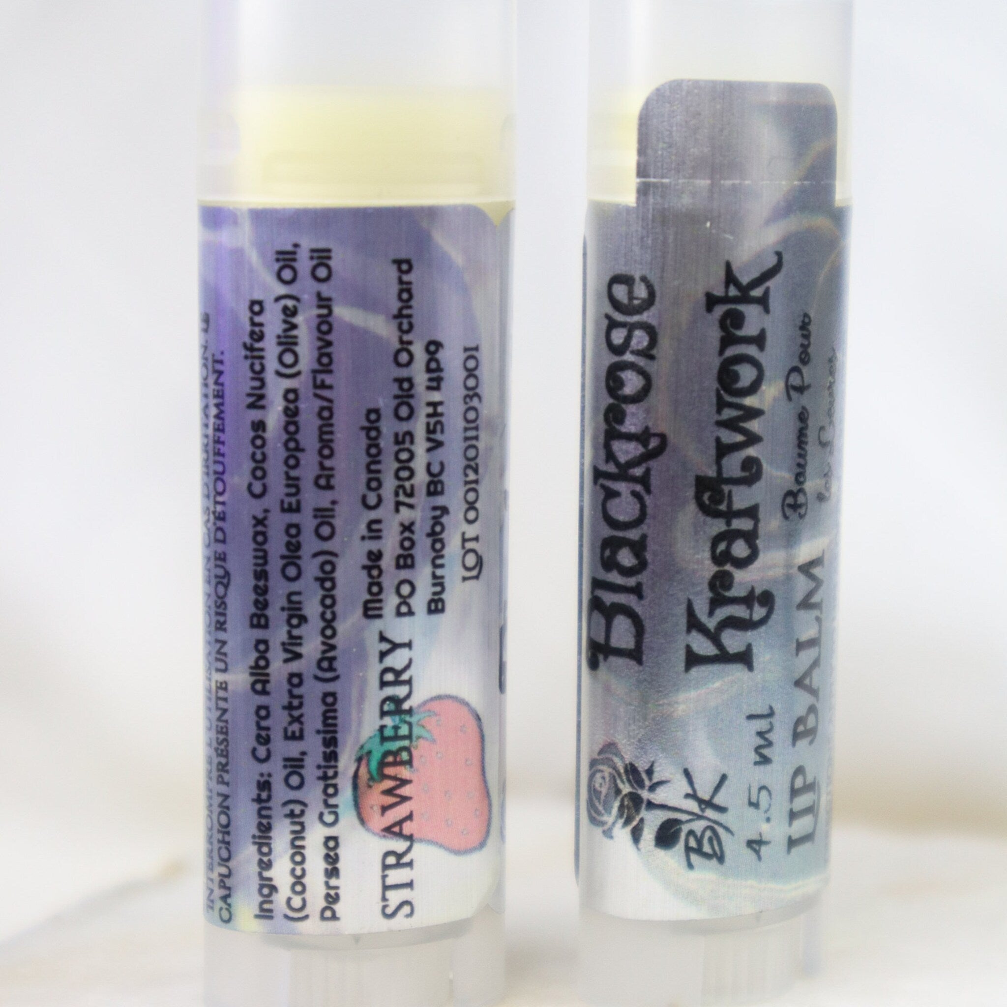 Lip balm tubes with purple and silver labels, Blackrose Kraftwork branding and strawberry graphic