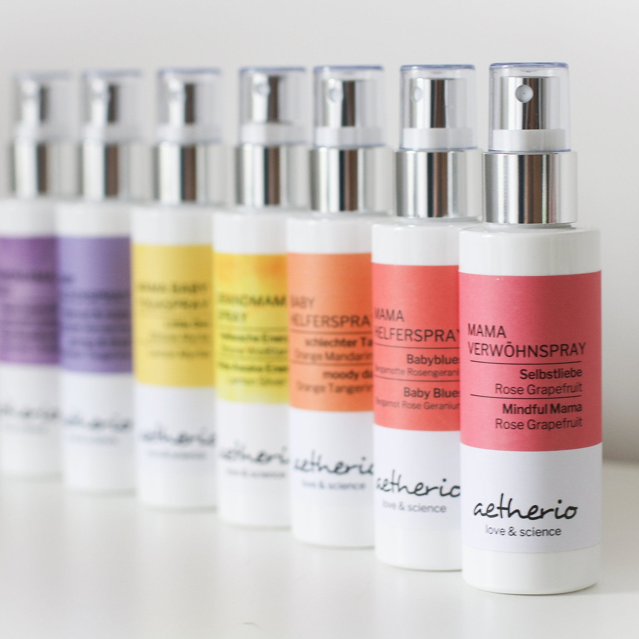 Spray bottles with white and colored labels, silver tops, and "aetherio" brand name visible