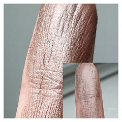 Side angle of Coco Bronze Beige Brown duochrome eyeshadow pan showing metallic chromatic shift in warm lighting