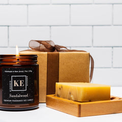 Bath & body gift set with brown candle, gift box, and soap on wooden tray