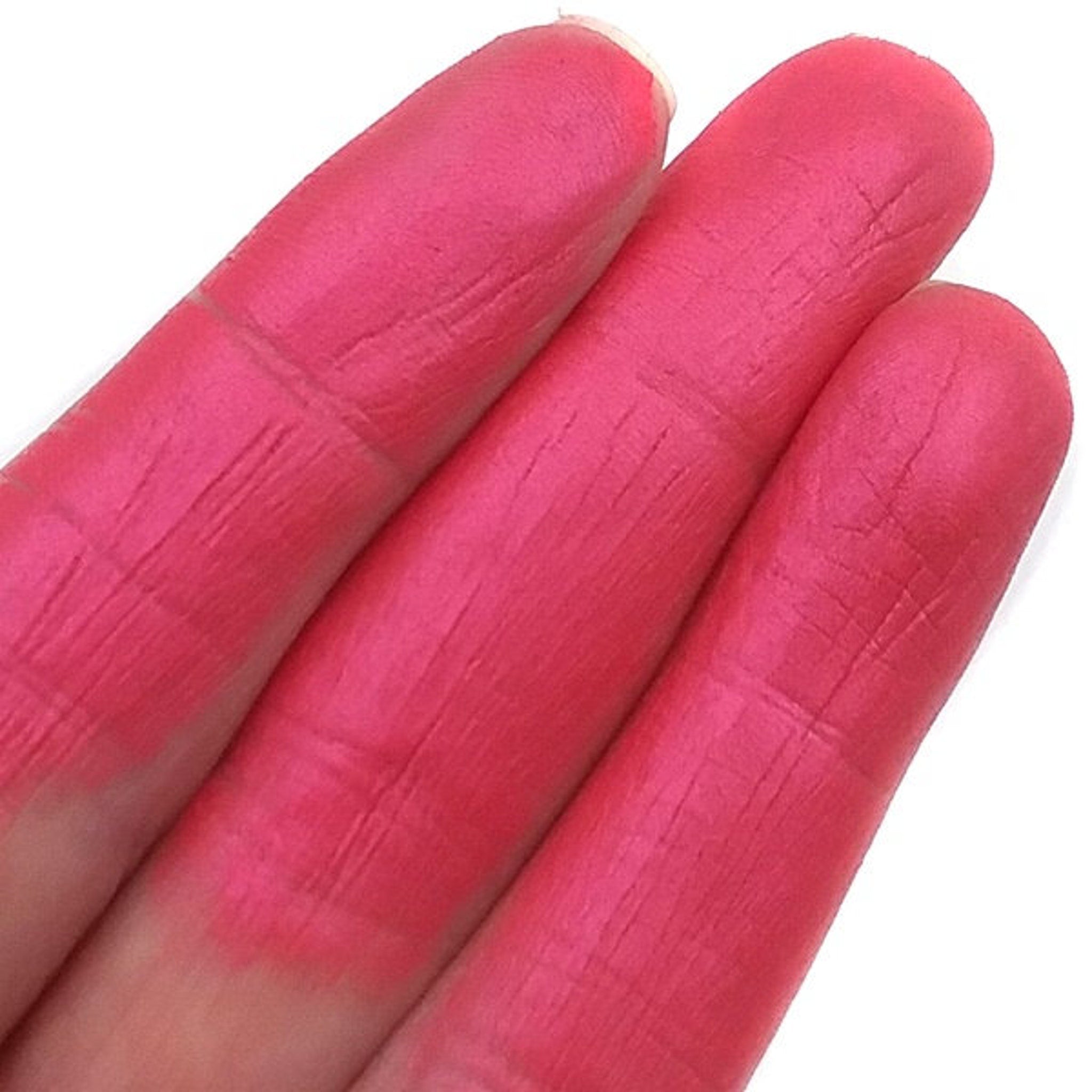 Woman applying pink mineral eyeshadow to eyelid with a fluffy makeup brush, showcasing smooth pigment blend
