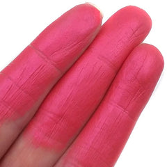 Woman applying pink mineral eyeshadow to eyelid with a fluffy makeup brush, showcasing smooth pigment blend