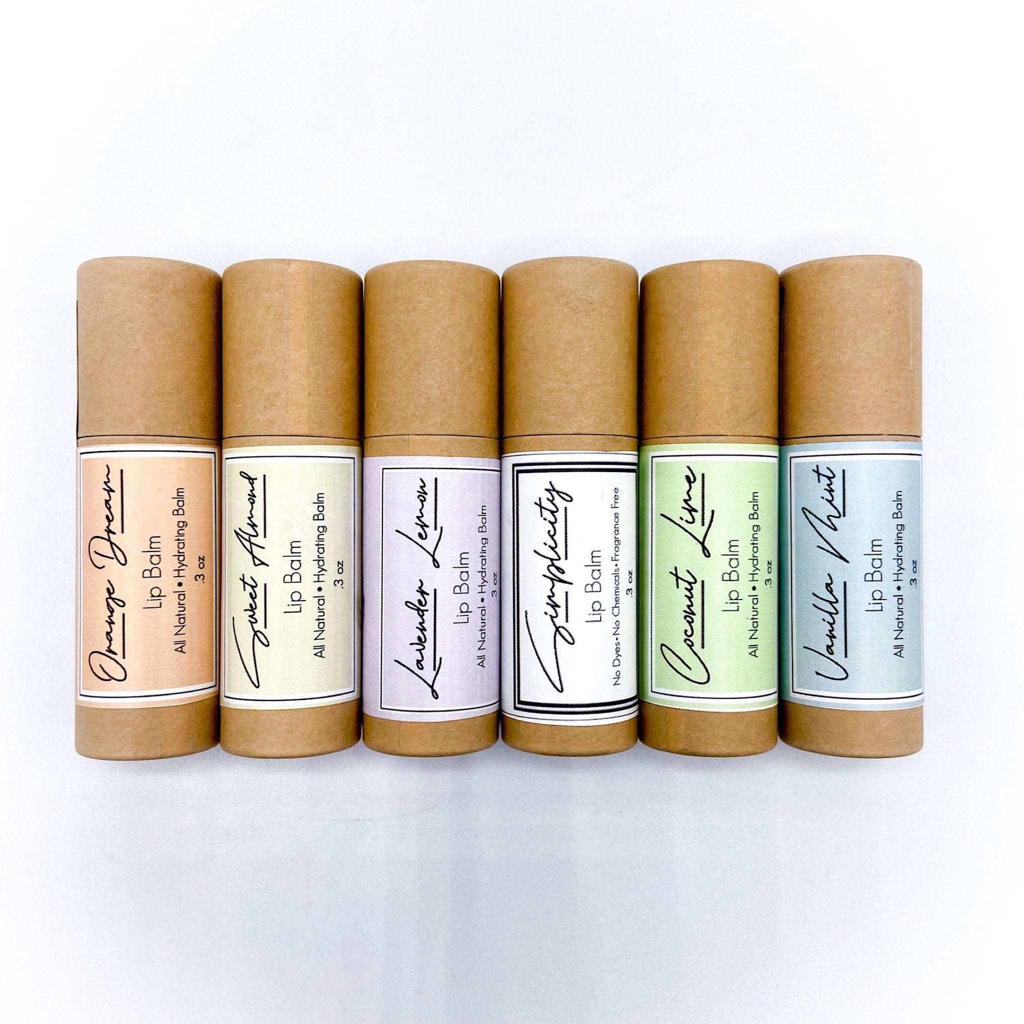 Lip balm tubes in brown, with colorful labels and script text, arranged on white surface