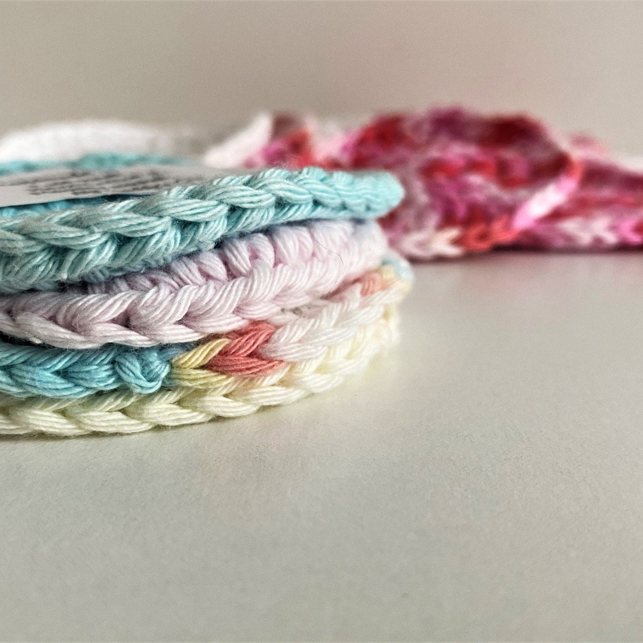 Crochet cotton face rounds, pastel colors, stacked, close up view