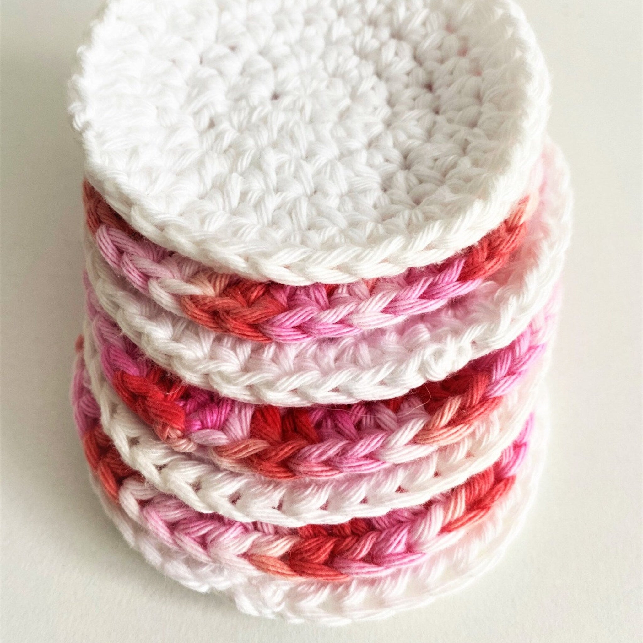 Crochet cotton rounds in white, pink, and red, stacked together