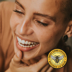 Lip balm product with smiling face, brown skin, and Sweet Comb Chicago logo visible