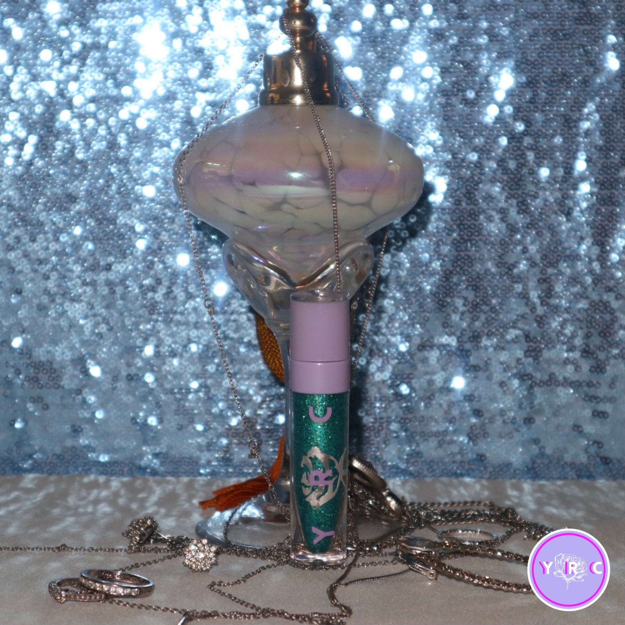 Close-up of a hand applying shimmery teal Sea Nymph eyeshadow with a blending brush