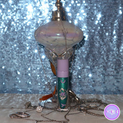 Close-up of a hand applying shimmery teal Sea Nymph eyeshadow with a blending brush
