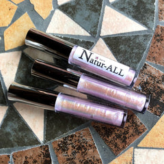 Lip gloss tubes with silver caps, iridescent pink gloss, and Natur-ALL label