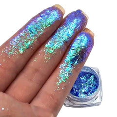 Close-up of iridescent Prism Chromaflake eyeshadow flakes shimmering with multicolor sparkles in a glass jar