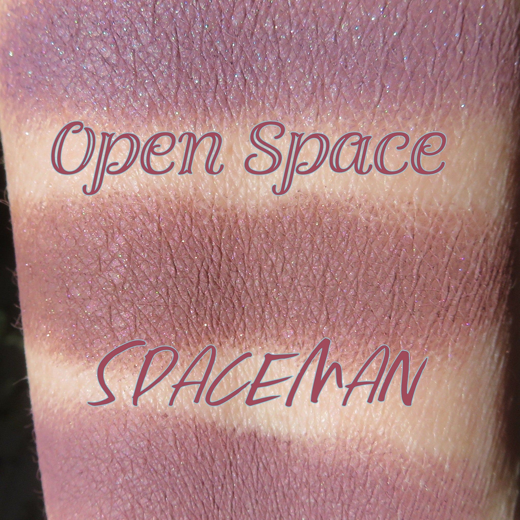 Swatch of purple eyeshadow with glitter, "Open Space" and "Spaceman" text visible