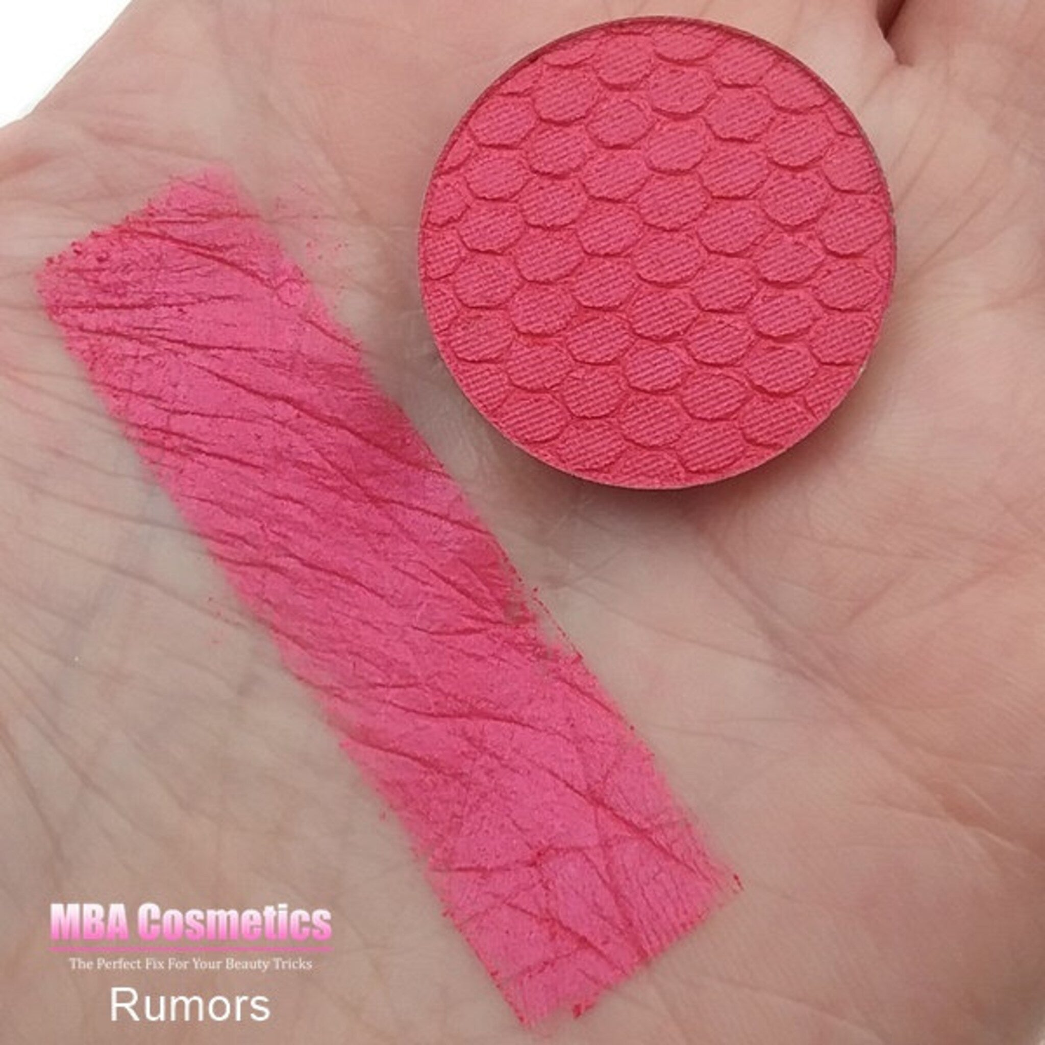 Close-up of pressed mineral eyeshadow pan showing soft pink shimmer with subtle gold undertones