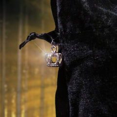 Silver crown charm pendant with black fabric, shiny detail, and ornate design.