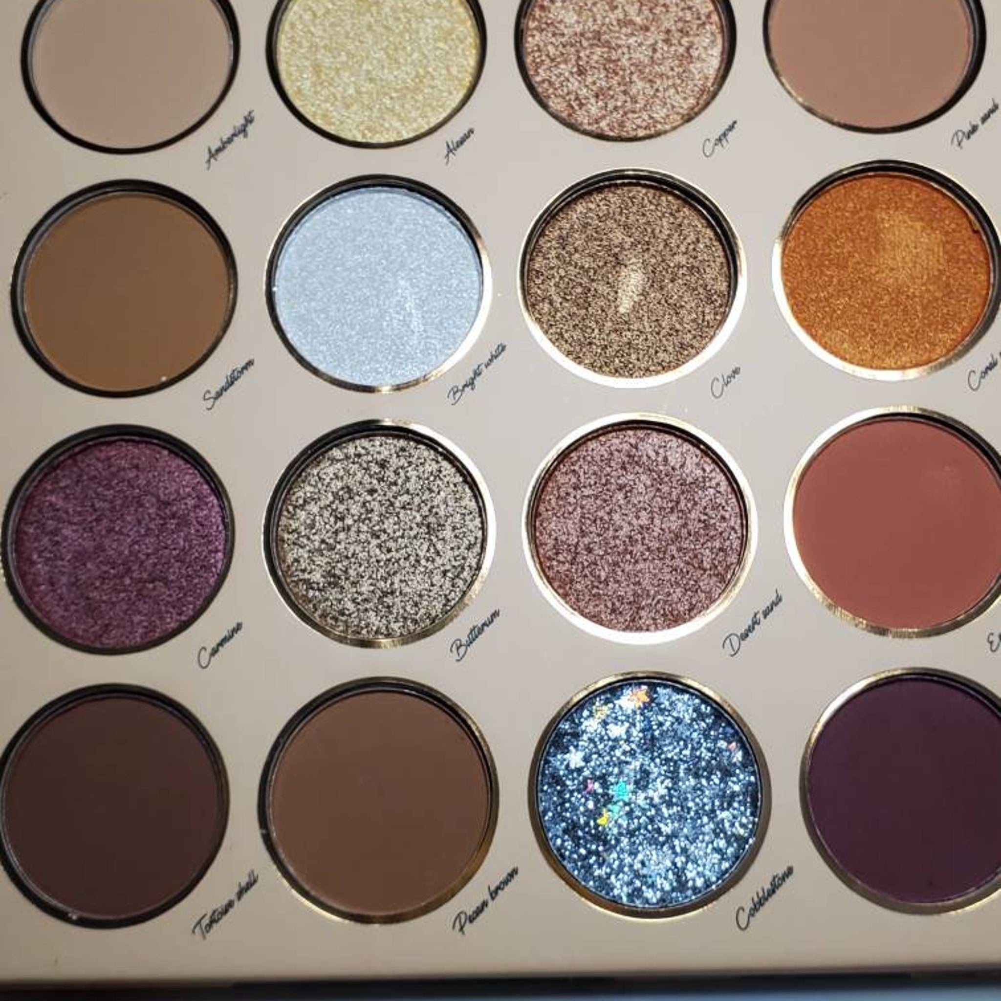 Close-up of sunflower yellow and rose pink matte eyeshadows with pressed floral imprint in palette