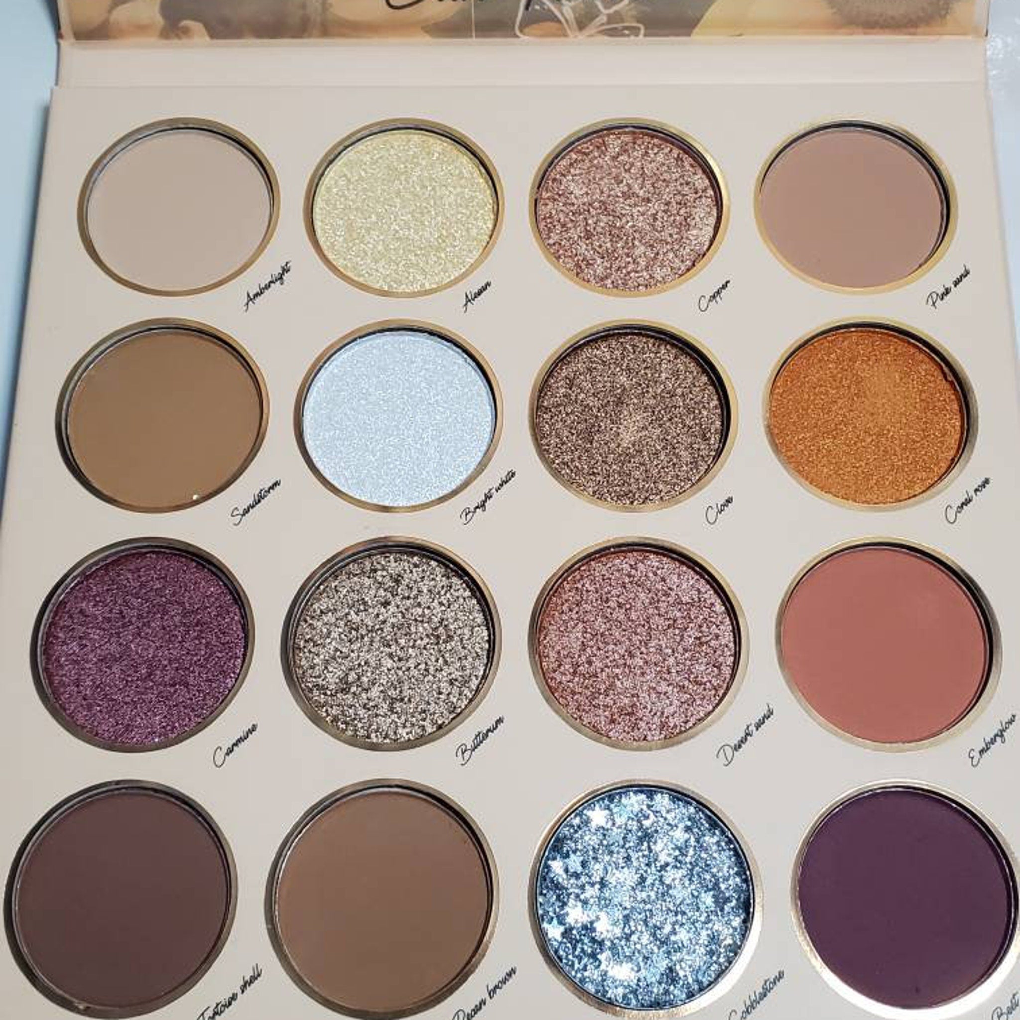 Sunflower Rose Garden eyeshadow palette open, displaying warm pink and gold shades in circular pans with floral design.