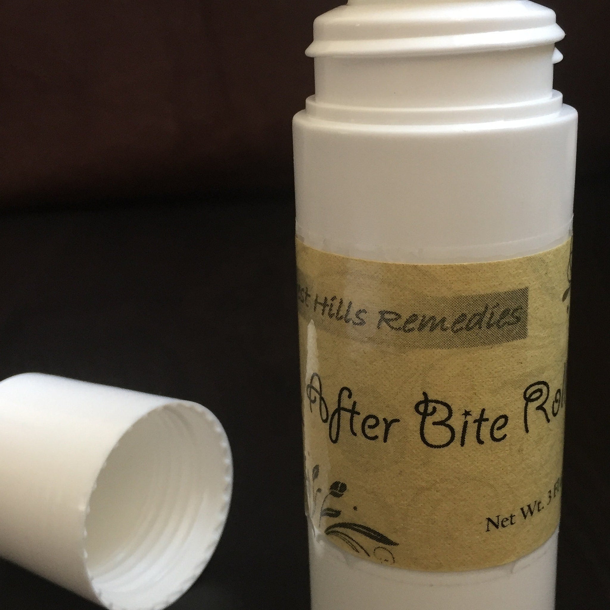 After Bite Roll-on white plastic bottle with tan label, black text, and lid off