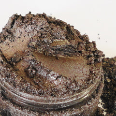 Side view of shimmering dark brown vegan eyeshadow in sifter jar showing mineral texture