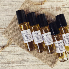 Eye serum bottles with black caps and amber liquid on burlap sack, A Wild Apothecary