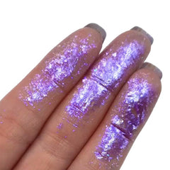 Hand applying iridescent Chromaflake Spectra Eyeshadow Flakes to eyelid with fingertip, showcasing shimmering multicolor flakes