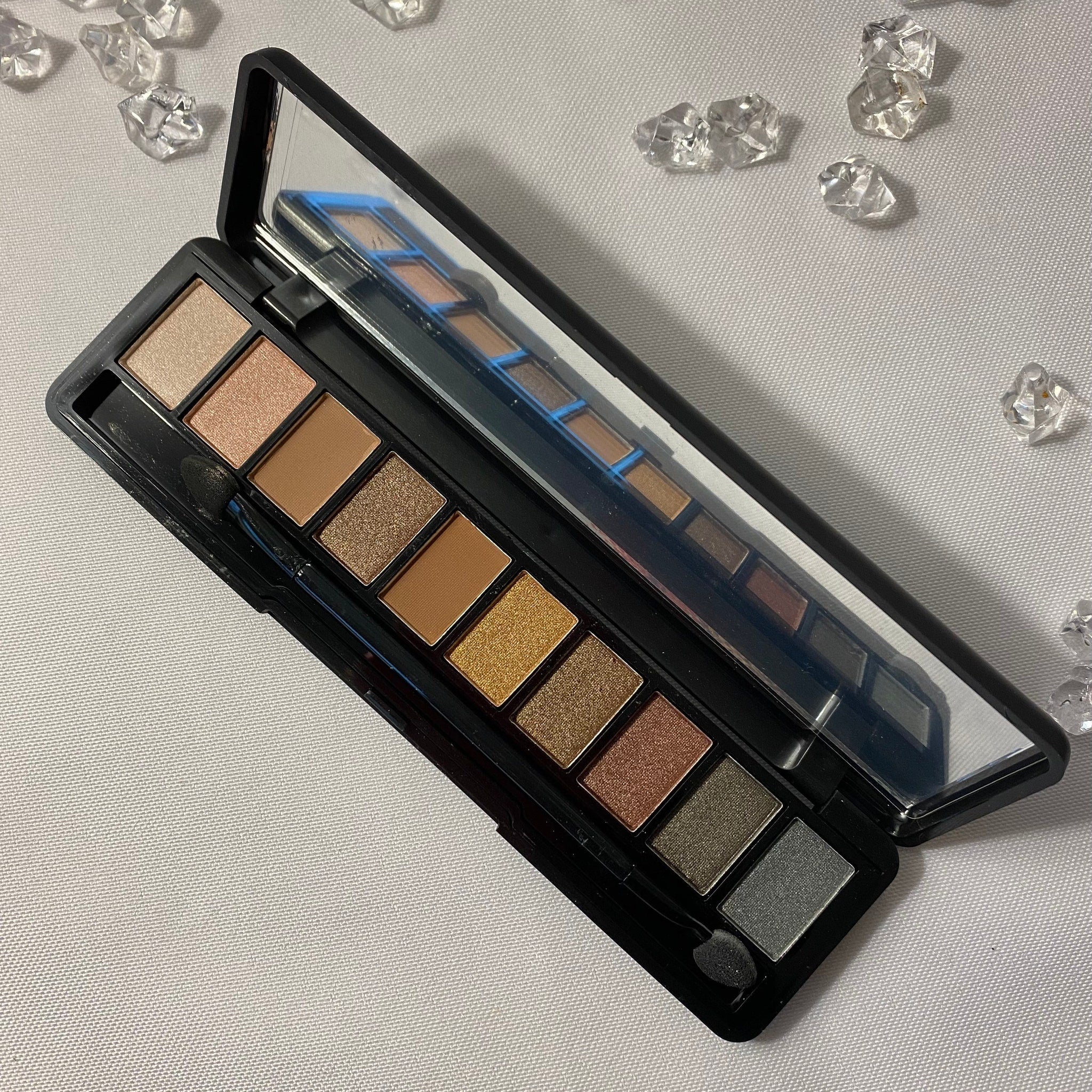 Vegan eyeshadow palette with six matte and shimmer shades in neutral browns and pinks, sleek black compact