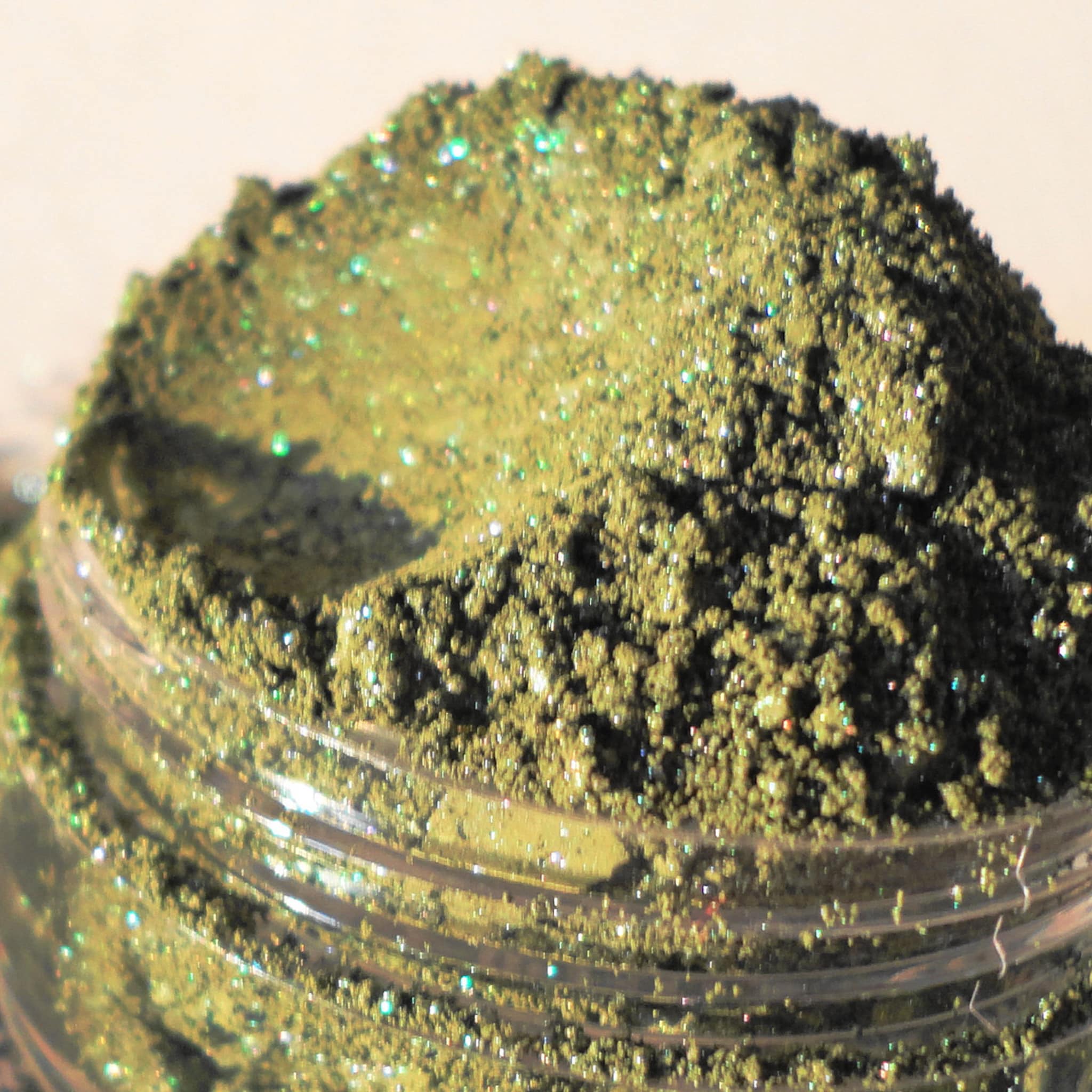 Close-up of dark navy blue eyeshadow pan showing intense metallic shimmer and smooth pressed powder texture