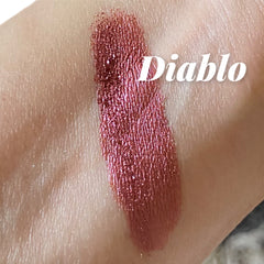 Close-up of vibrant vegan red eye shadow powder in a petite black sifter jar with mineral shimmer