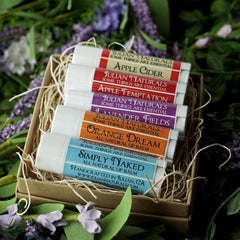 Lip balms with white tubes, colorful labels, and Julian Naturals brand name in a gift box