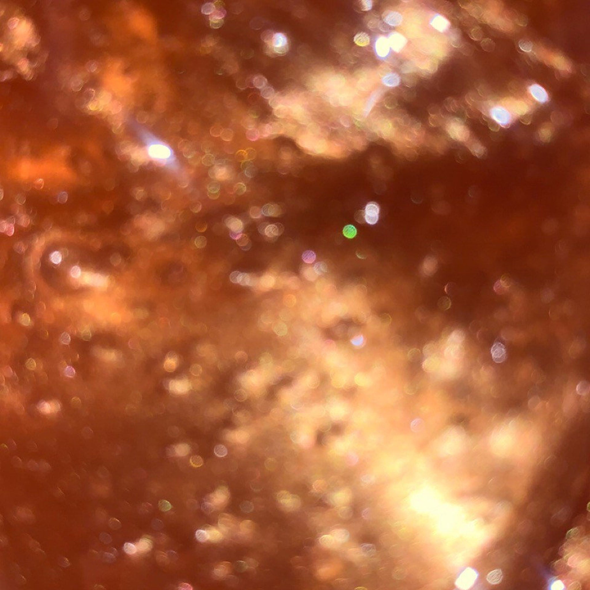 Orange glitter bokeh background with light reflections and blurred texture