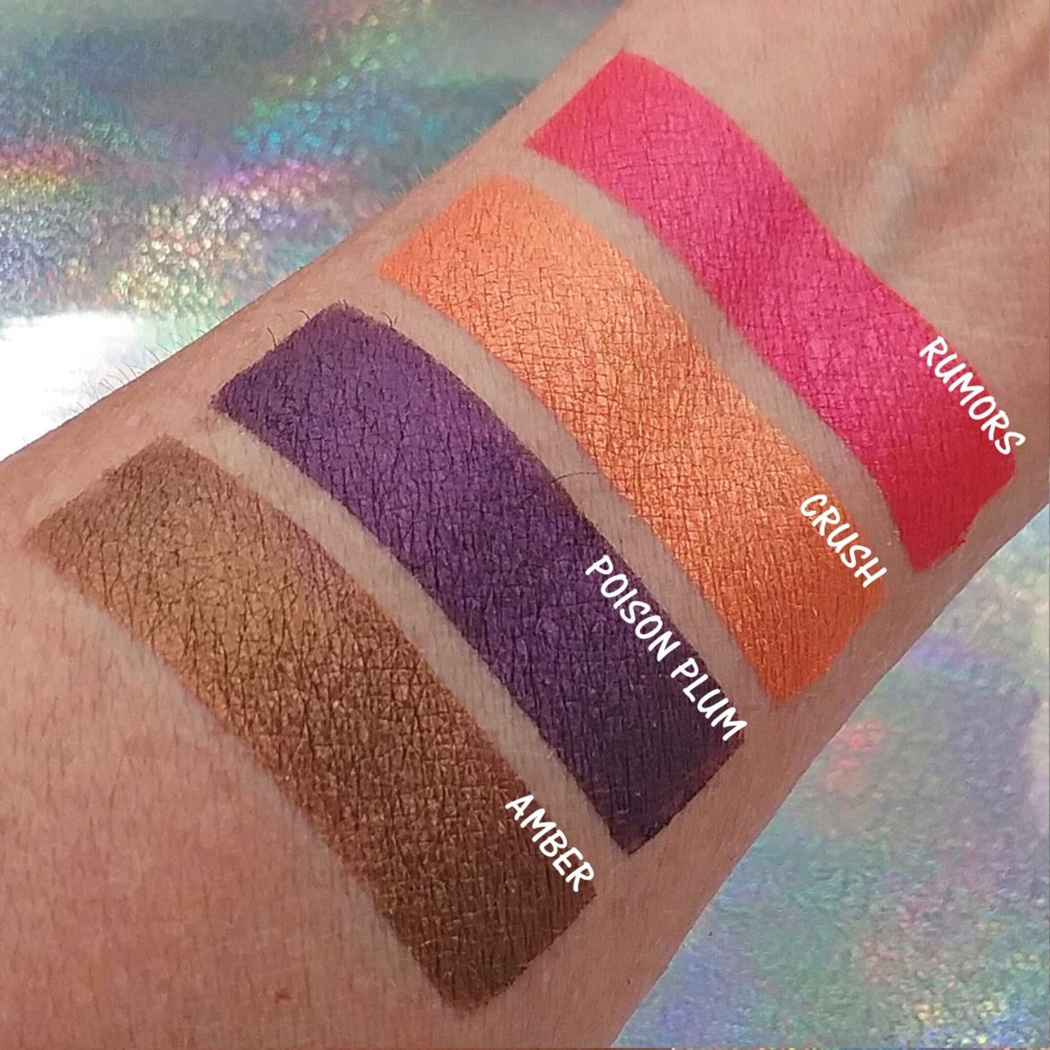 Pressed mineral eyeshadow in soft pink with shimmer finish, shown swatched on fingertip