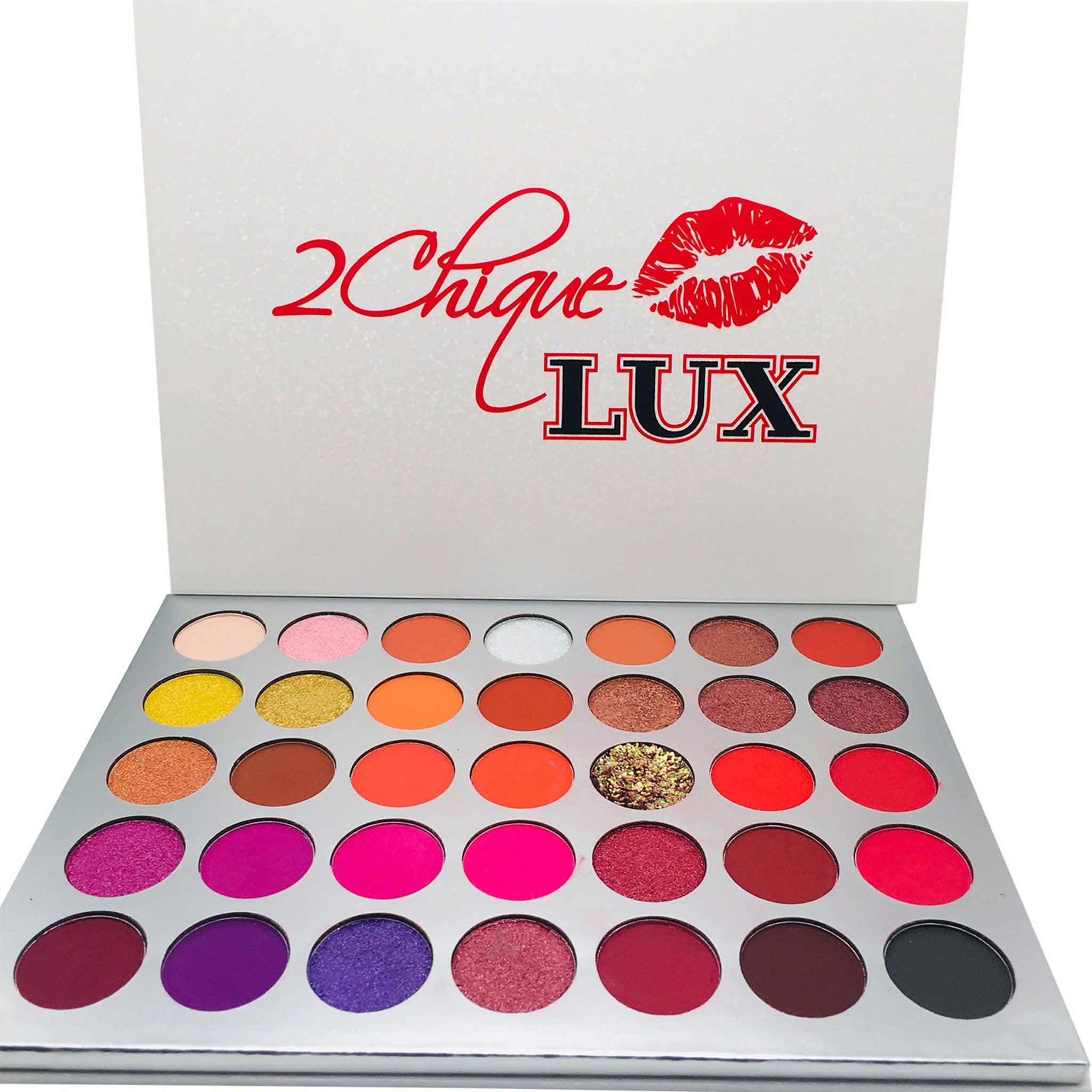 Eyeshadow palette with multiple colors, silver case, and 2Chique Boutique logo