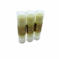 Lip balm tubes with clear plastic casing, light yellow balm, and brand label Salvatore Trip