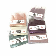 Mineral eye shadow in pink, purple, and green colors, in clear plastic bags, with brand labels visible