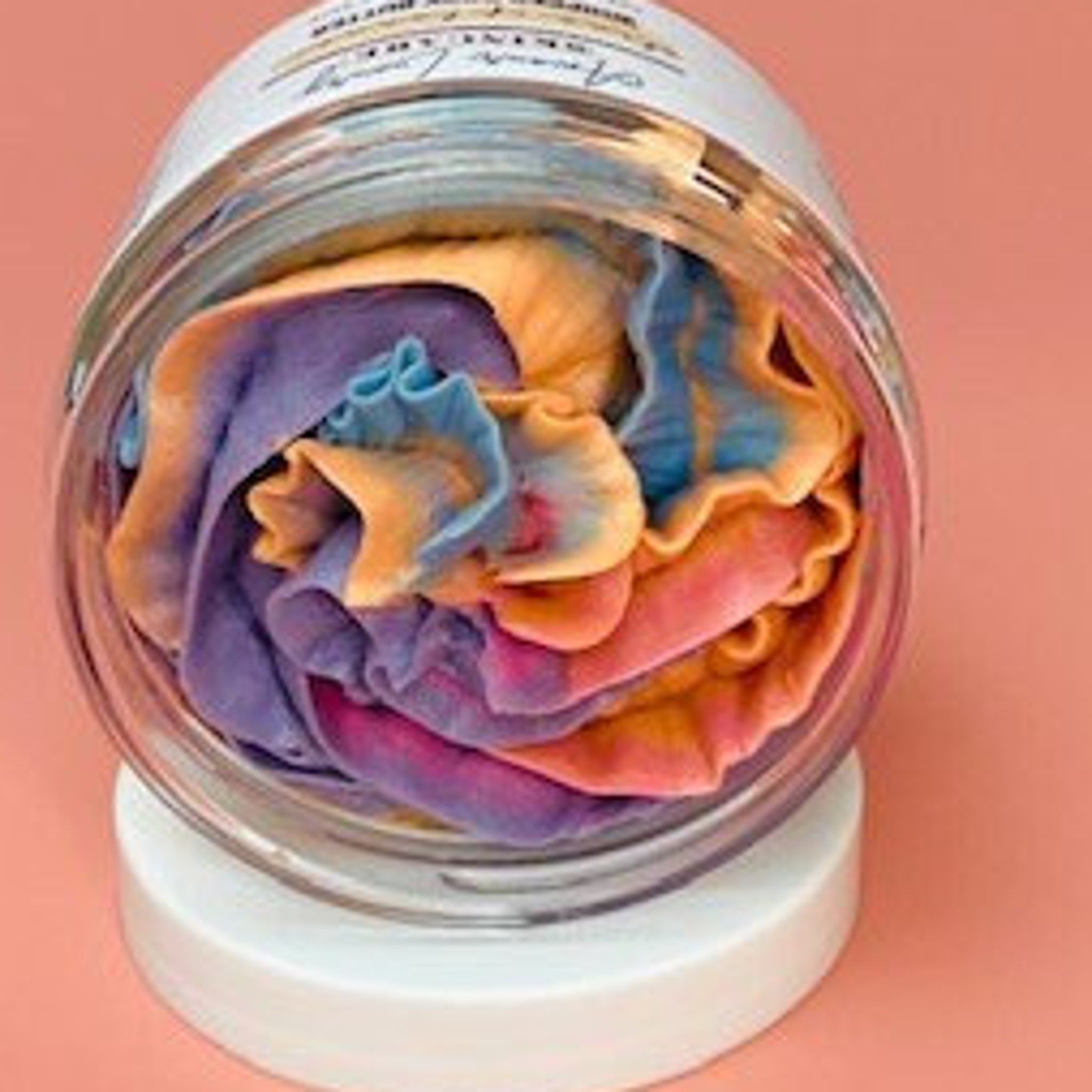Side view of golden jar with whipped passionfruit-scented shea butter, showcasing its creamy texture and luxe packaging