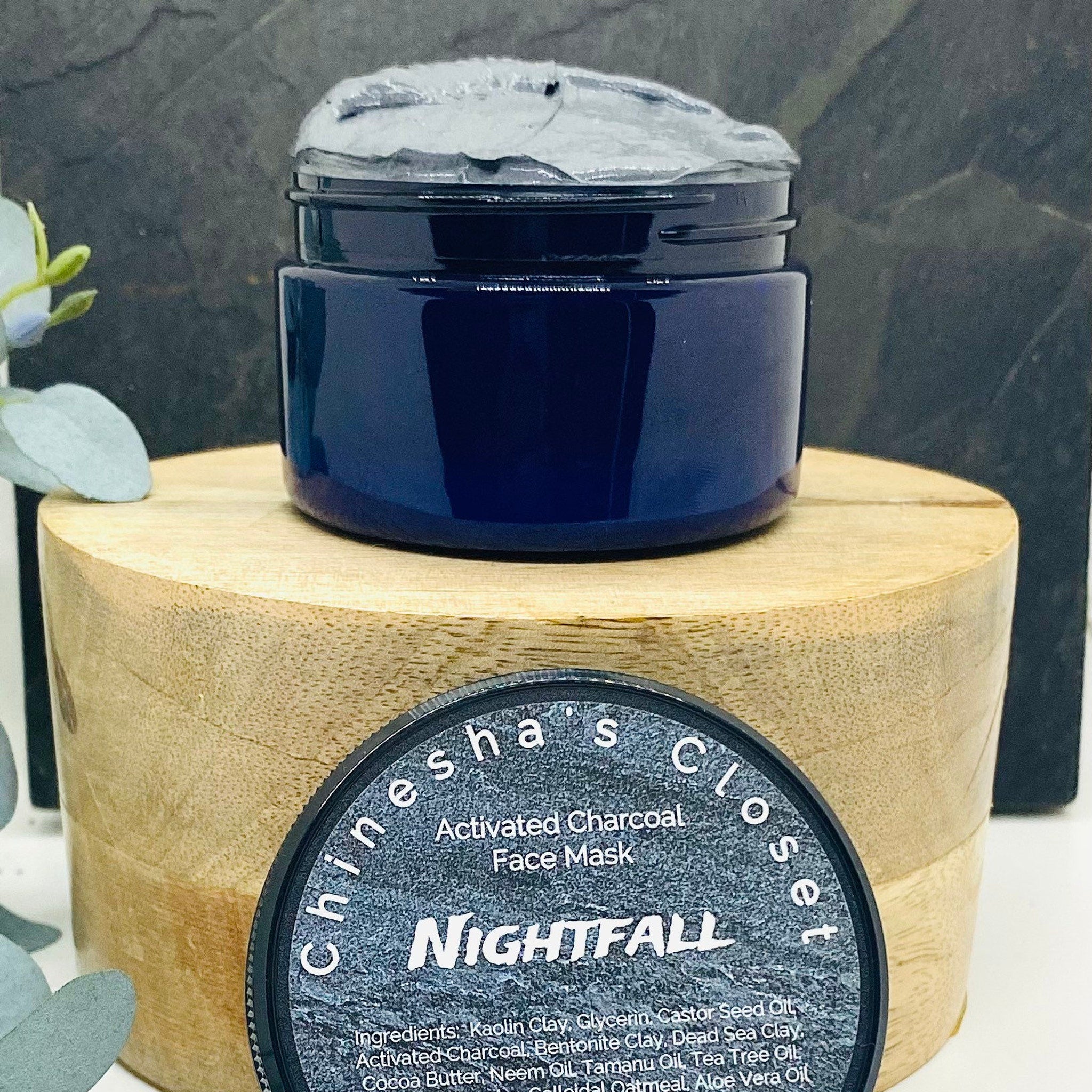 Activated charcoal face mask in dark blue jar with grey mask and brand name NIGHTFALL visible