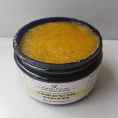 Side angle of golden turmeric scrub in amber jar with wooden scoop on textured linen, showcasing earthy tones