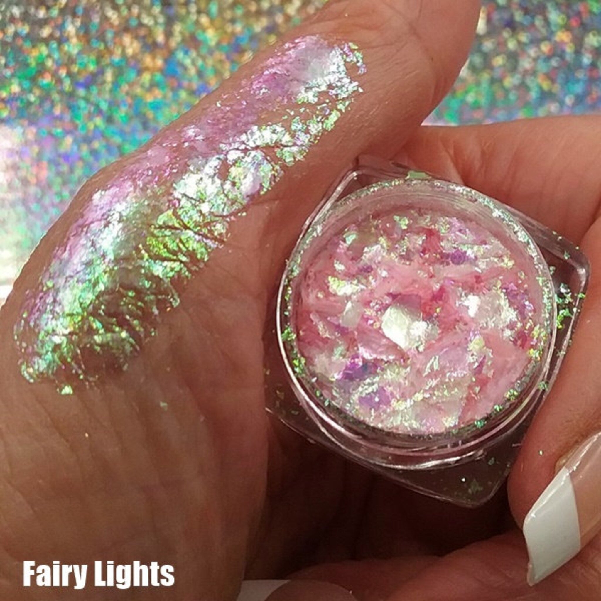 Flatlay of Fairy Magic Chromaflake Eyeshadow palette showing six iridescent shades in circular pans with holographic packaging