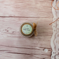 Sugar scrub jar with cork lid, paper label, and twine bow on wood background