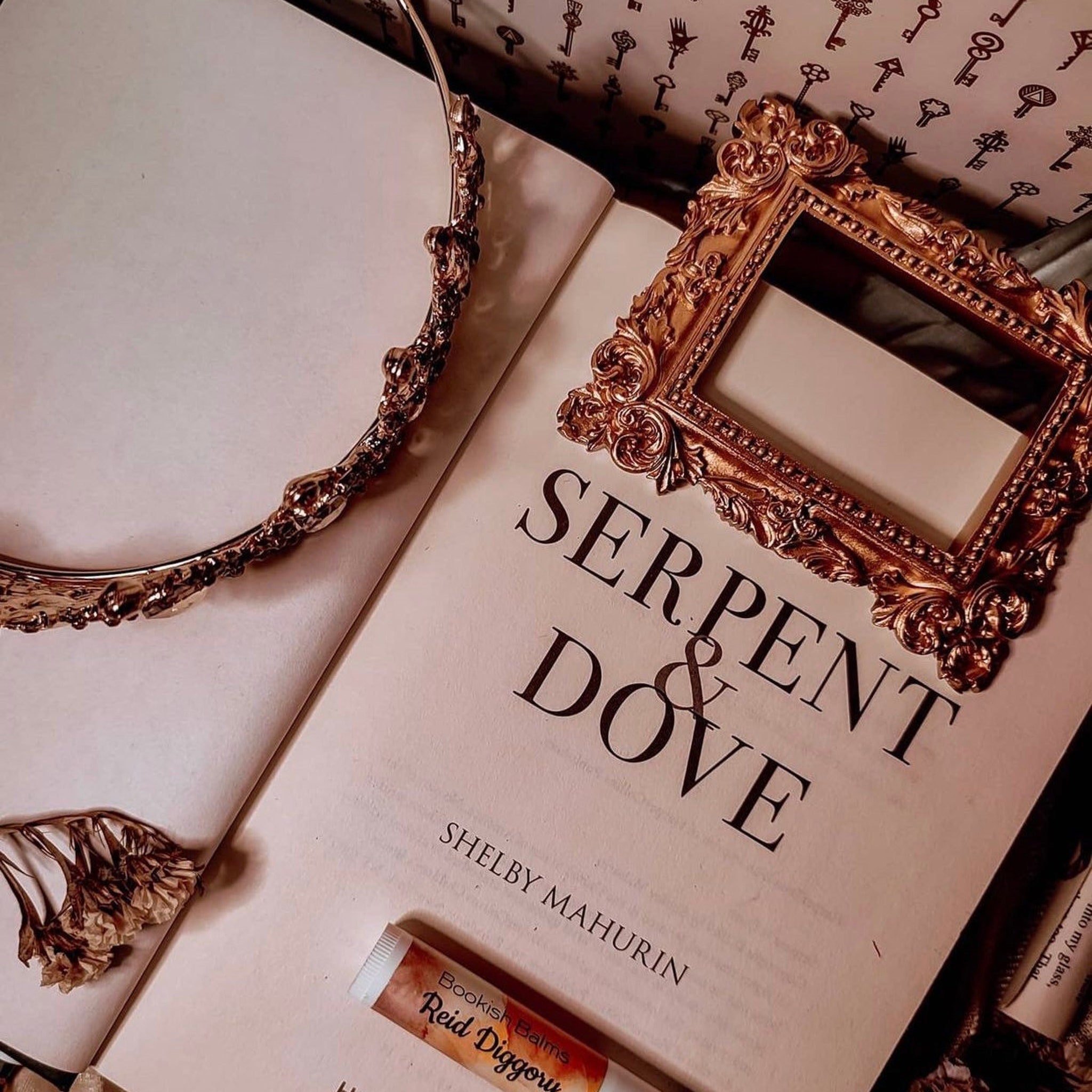 Book cover with gold frame, ornate style, and "Serpent & Dove" title
