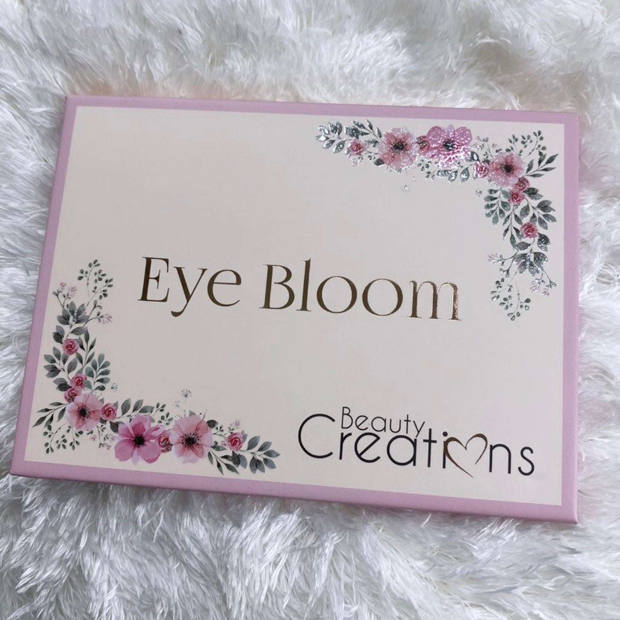 Bloom Eyeshadow Palette featuring twelve vibrant matte and shimmer shades in a sleek black compact