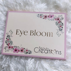 Bloom Eyeshadow Palette featuring twelve vibrant matte and shimmer shades in a sleek black compact