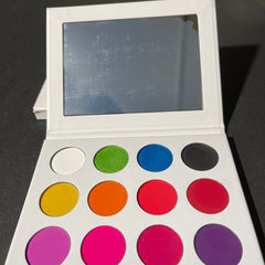 Close-up of Walter Tucci eyeshadow palette showing vibrant matte and shimmer shades in rich jewel tones